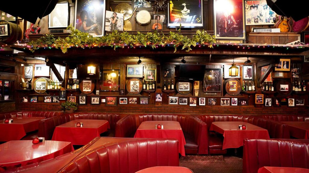 Interior of Rainbow Bar & Grill with red booths and music memorabilia on the walls