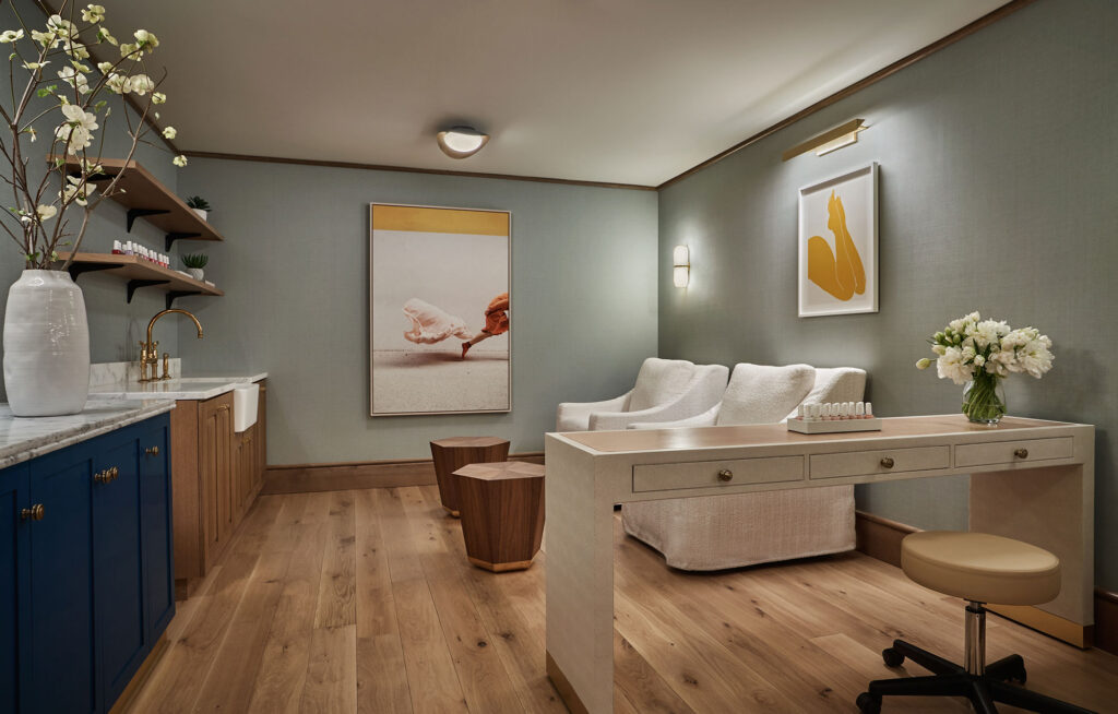 A treatment room at Spa Pendry at the Pendry West Hollywood, which has two white chairs and a table for nail treatments.