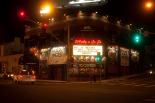 Exterior of Whisky a Go Go with its red neon sign lit up at night.