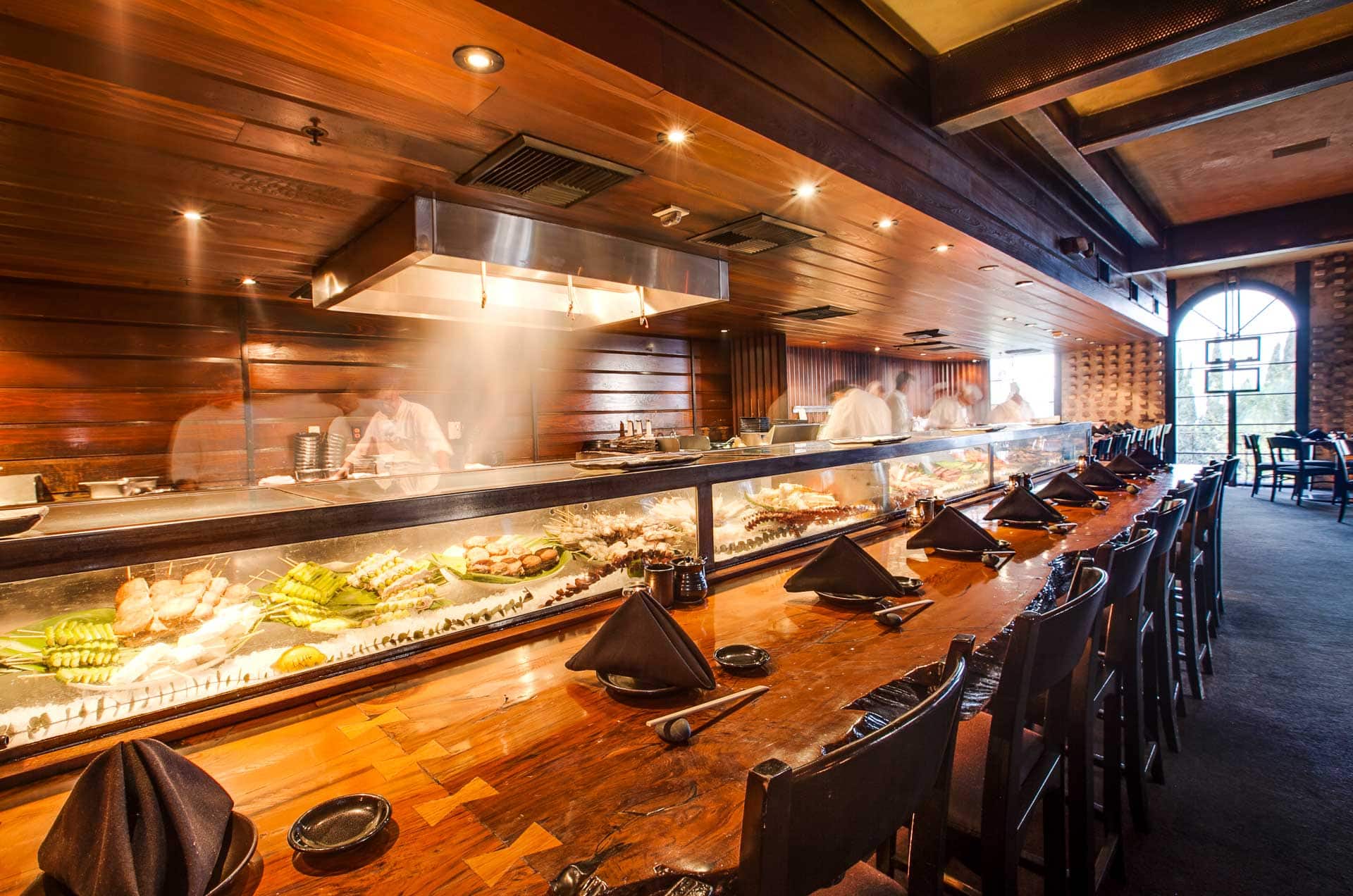 Chefs work behind the long sushi bar at Katana in West Hollywood, California.