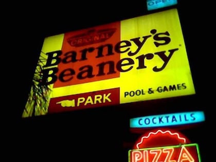 The bright neon-yellow Barney's Beanery sign, advertising pool, games, cocktails and pizza.