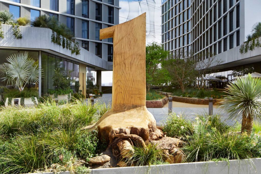 A large wooden number one, carved out of a tree trunk, in between the two buildings that make up 1 Hotel West Hollywood.