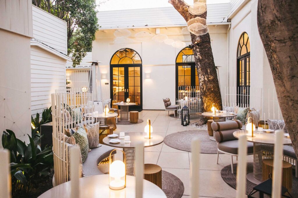 The exterior patio of Somni, with unique, modern furniture and lanterns on each table.