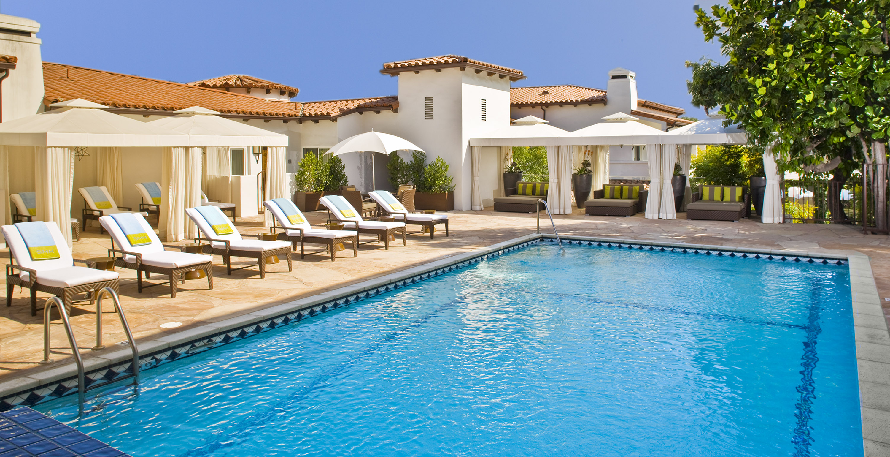 Outdoor pool at the Spanish Villa-style Sunset Marquis with white-cushion lounge chairs.