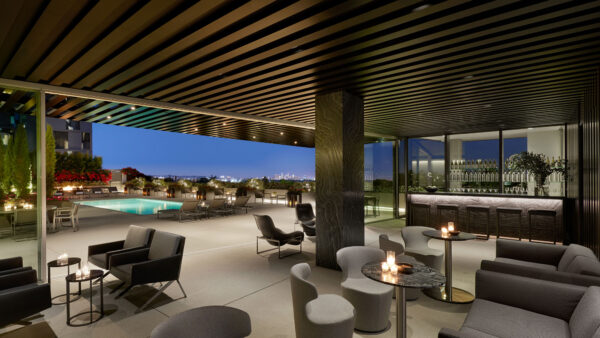Mid-century modern-style outdoor lounge at AKA West Hollywood, with a swimming pool in the background.