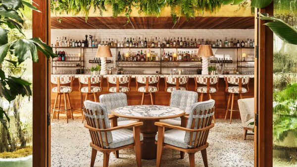 A doorway framed with foliage looks into a bar/restaurant at Soho House Holloway. West Hollywood, California.