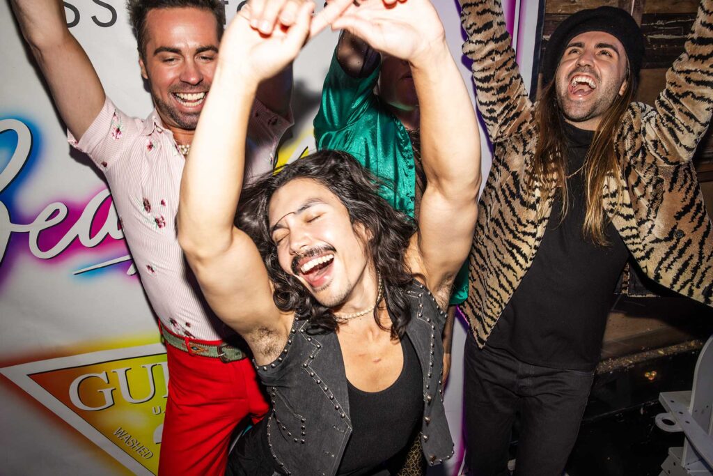 Three LGBTQ+ people dance at Beaches nightclub in West Hollywood, California.