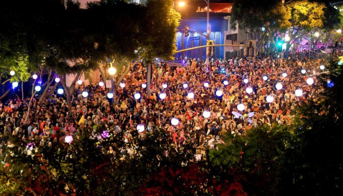 A large crowd of costumed revelers gathers on Santa Monica Boulevard for the West Hollywood Halloween Carnaval.