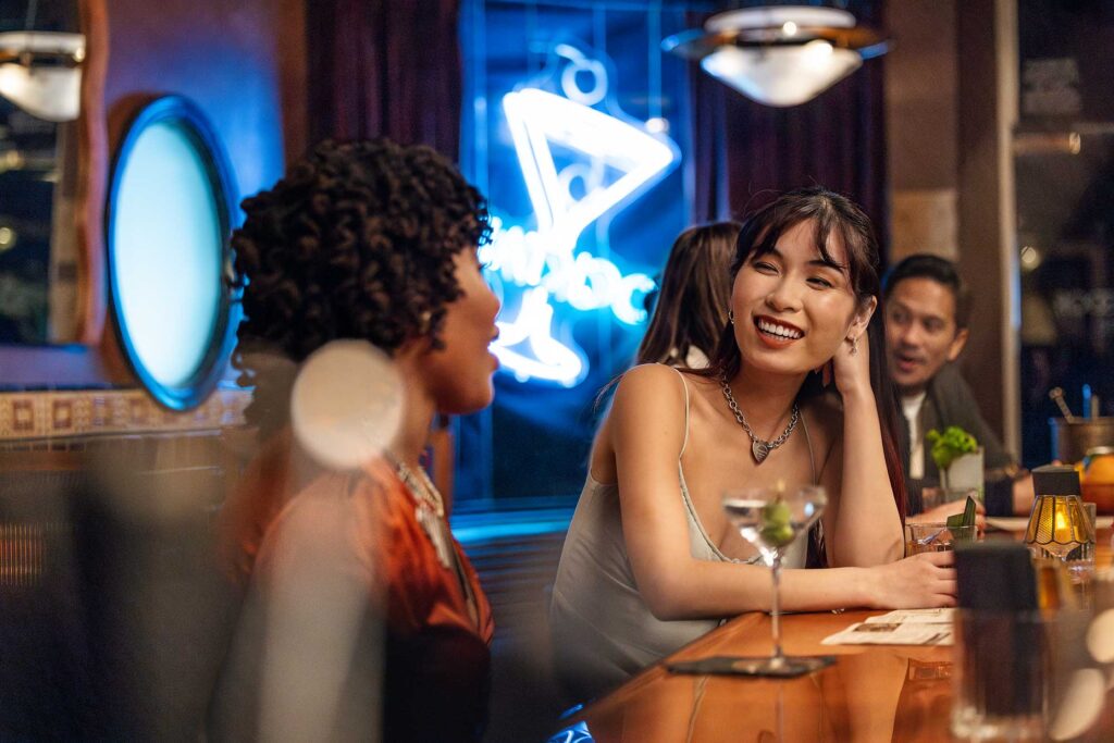 Two women sit at the bar with cocktails at The Bar Next Door in West Hollywood, California.