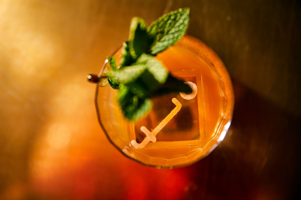 Overhead shot of a cocktail in a rocks glass and a sprig of mint at Employees Only LA. West Hollywood, California.