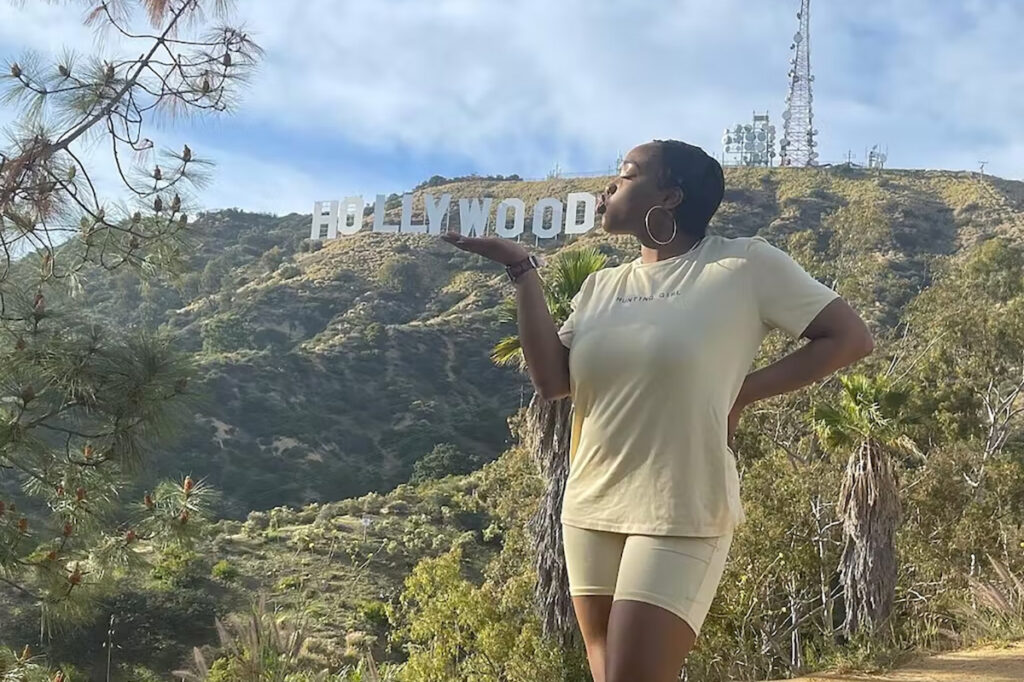 A woman "kisses" the Hollywood sign in a fun photo opp.
