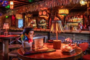 Retro-styled interior of The Lucky Tiki, with drink glass in the shape of Elvis sitting on a table.