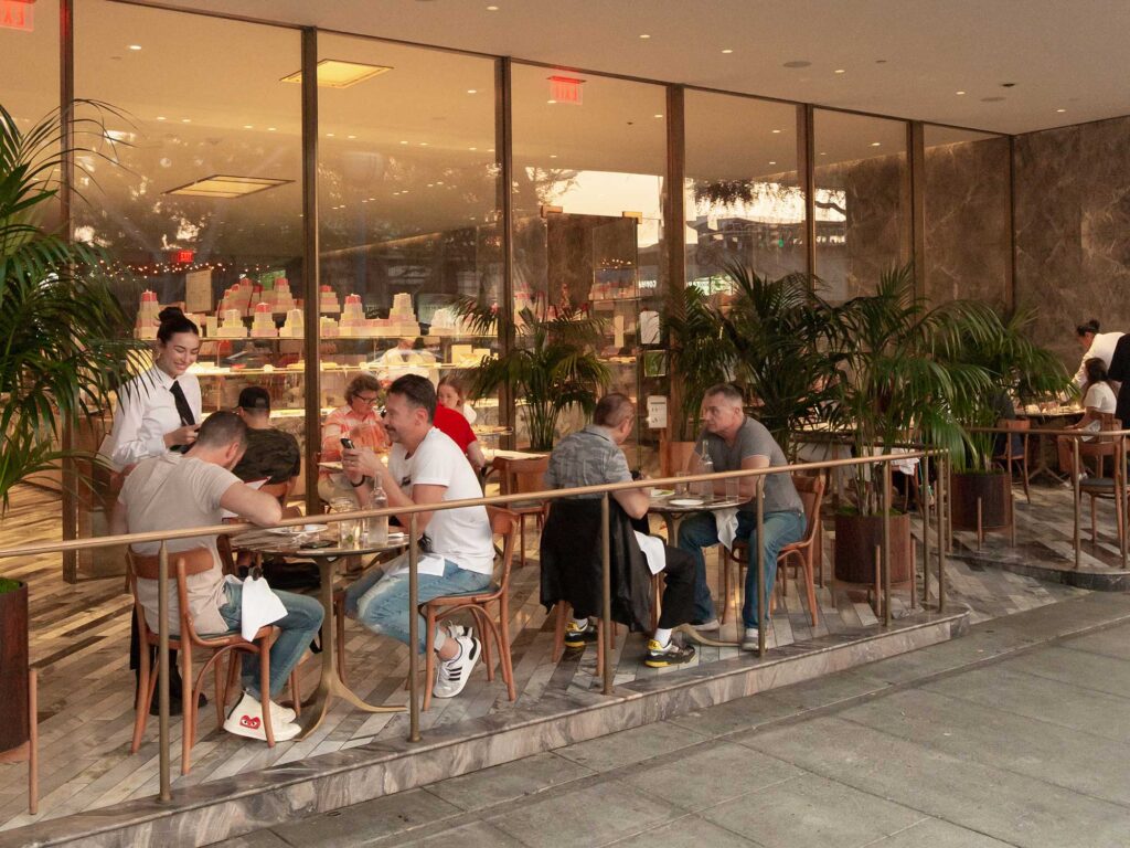 Diners sit at outdoor tables at Bottega Louie in West Hollywood, California.