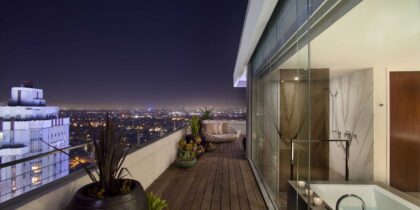 A luxurious penthouse suite with balcony at Andaz West Hollywood, photographed at night