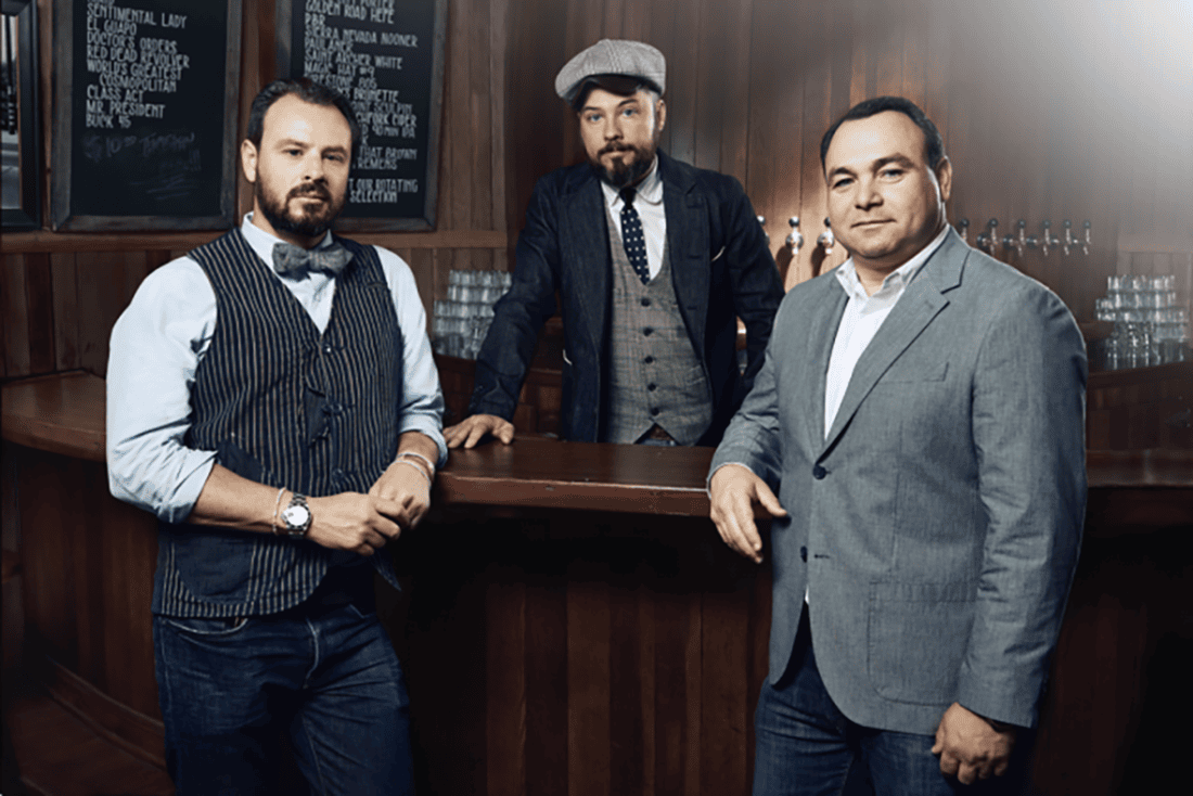 Three men post wearing vintage-style suits.