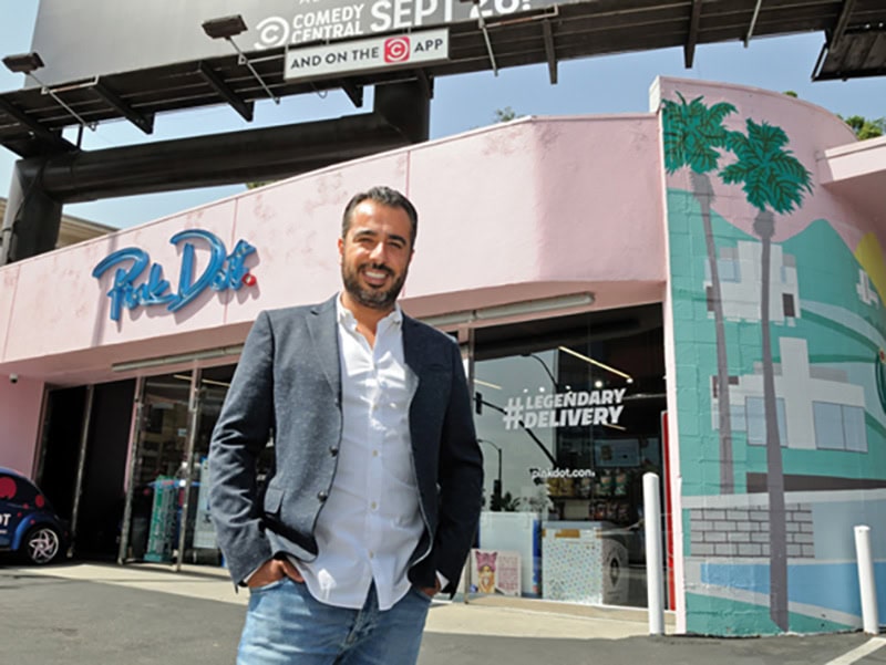 A man, Sol Yamini, stands in front of Pink Dot in West Hollywood, California
