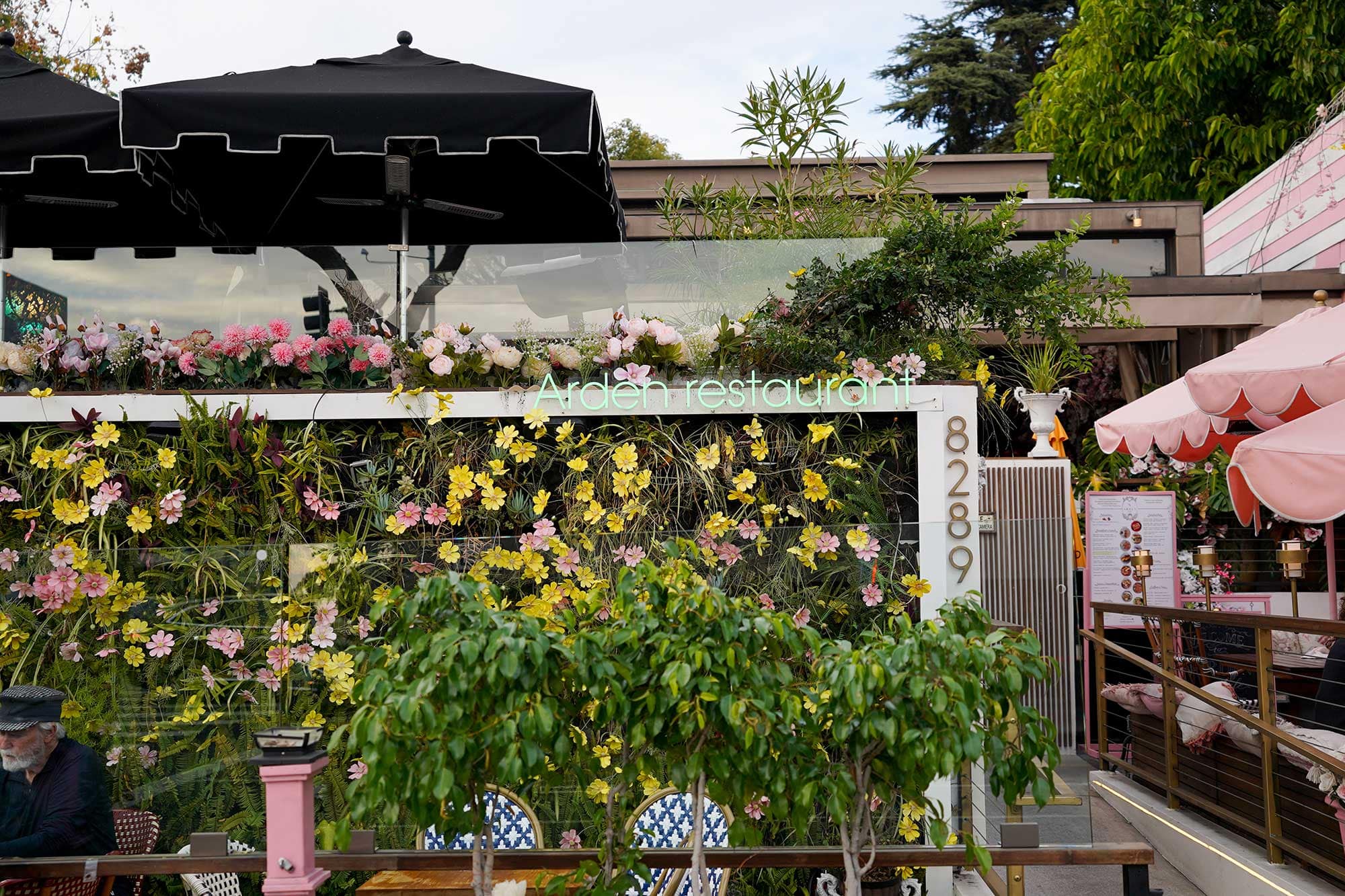 Exterior of Arden Restaurant in West Hollywood, featuring a wall of flowers in front of an outdoor patio.