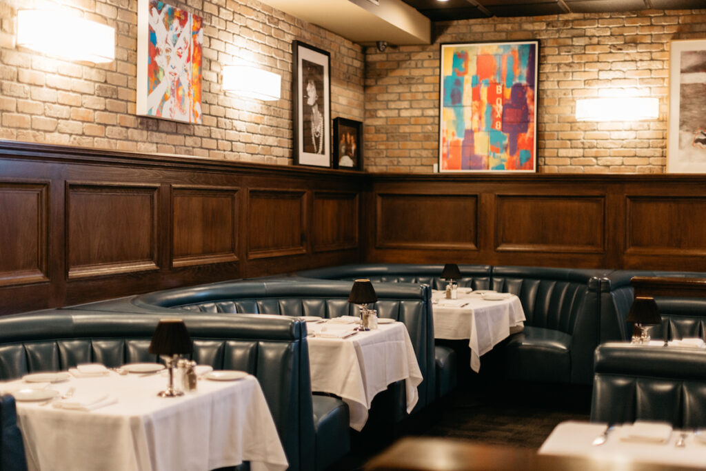 Interior of Craig's West Hollywood, with circular booths and white tablecloths.