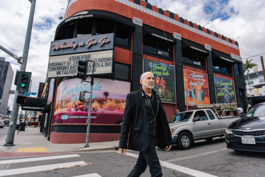 A man crosses the street in front of the Whisky a Go Go nightclub on Sunset Boulevard