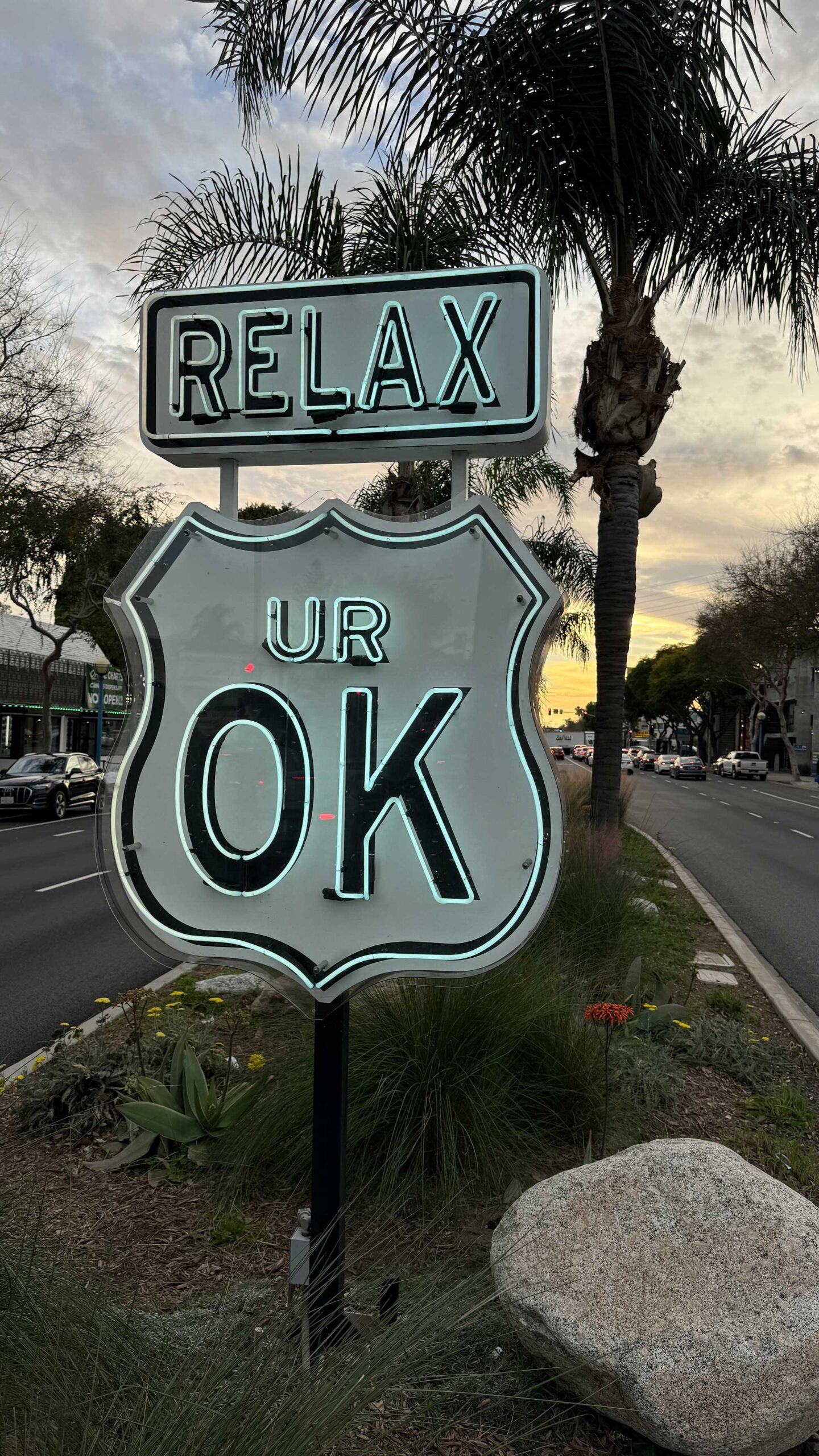 A neon sign in West Hollywood reads "Relax UR OK"