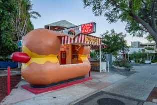 Tail O' the Pup hot dog stand is lit up at twilight
