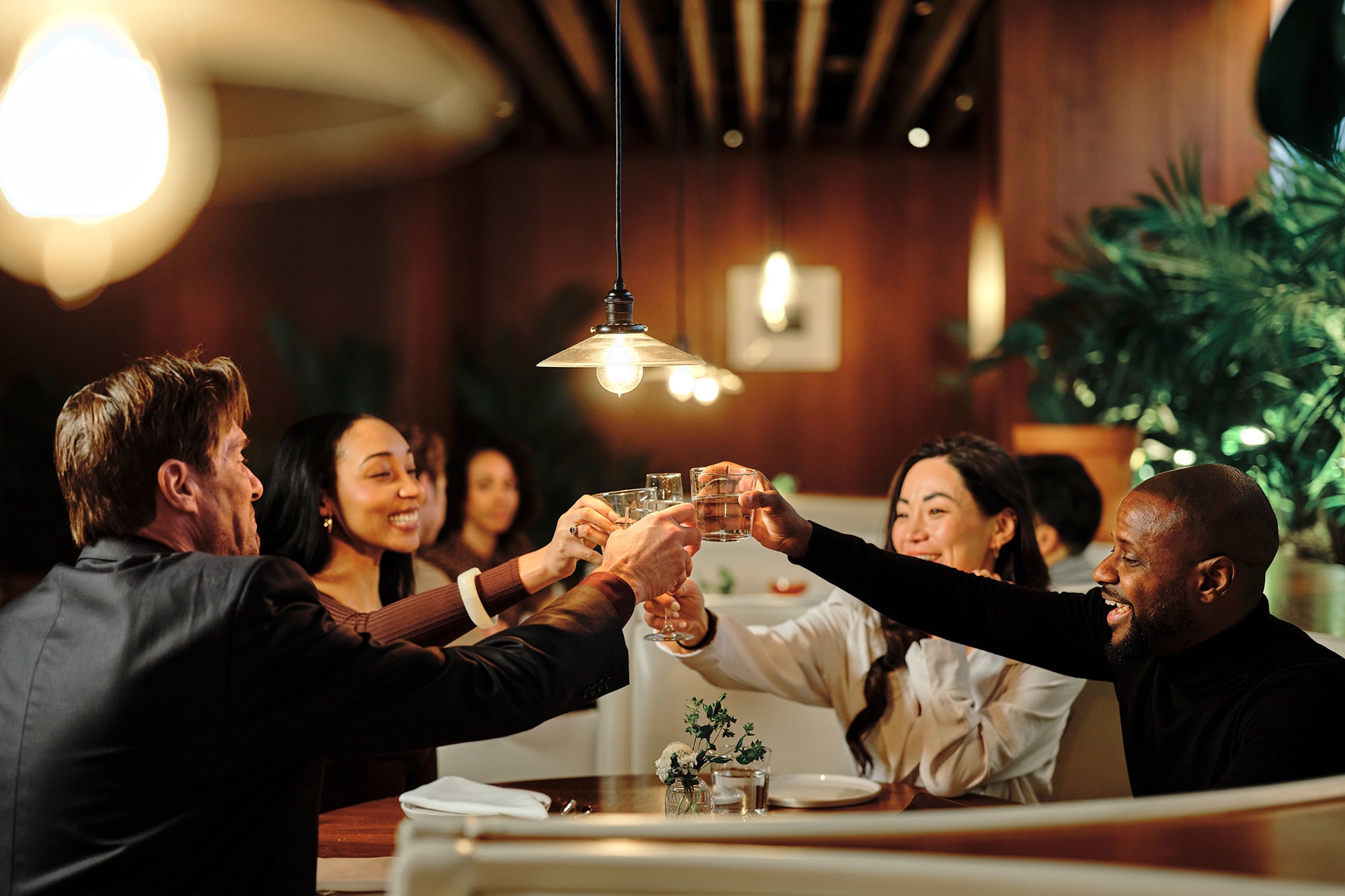 A group of people raise glasses at a dinner in West Hollywood