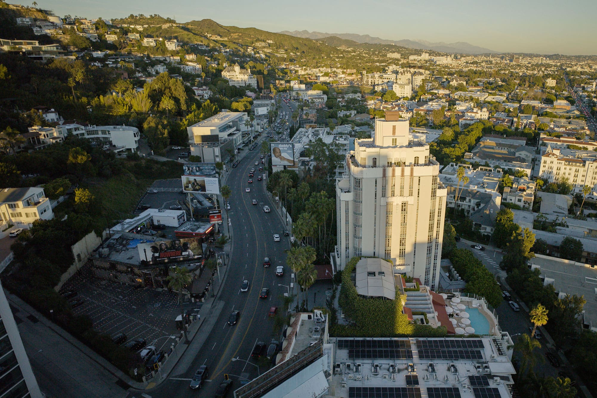 Drone shot of the Sunset Strip with the Sunset Tower Hotel in the foreground