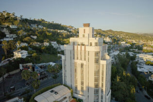 A drone shot of Sunset Boulevard with the Sunset Tower Hotel in the foreground