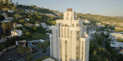 A drone shot of Sunset Boulevard with the Sunset Tower Hotel in the foreground