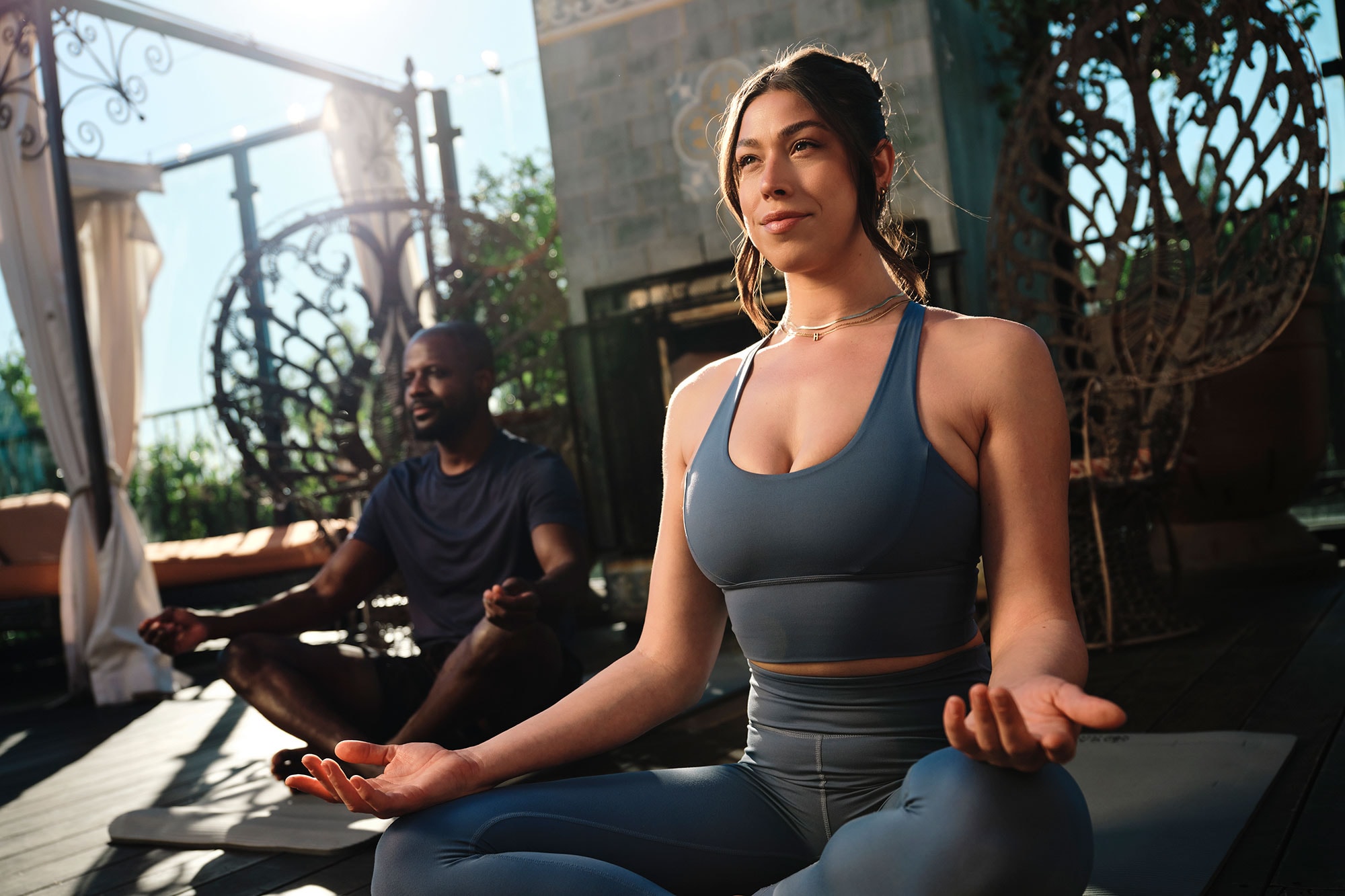 A man and a woman practice yoga on a rooftop in West Hollywood, CA