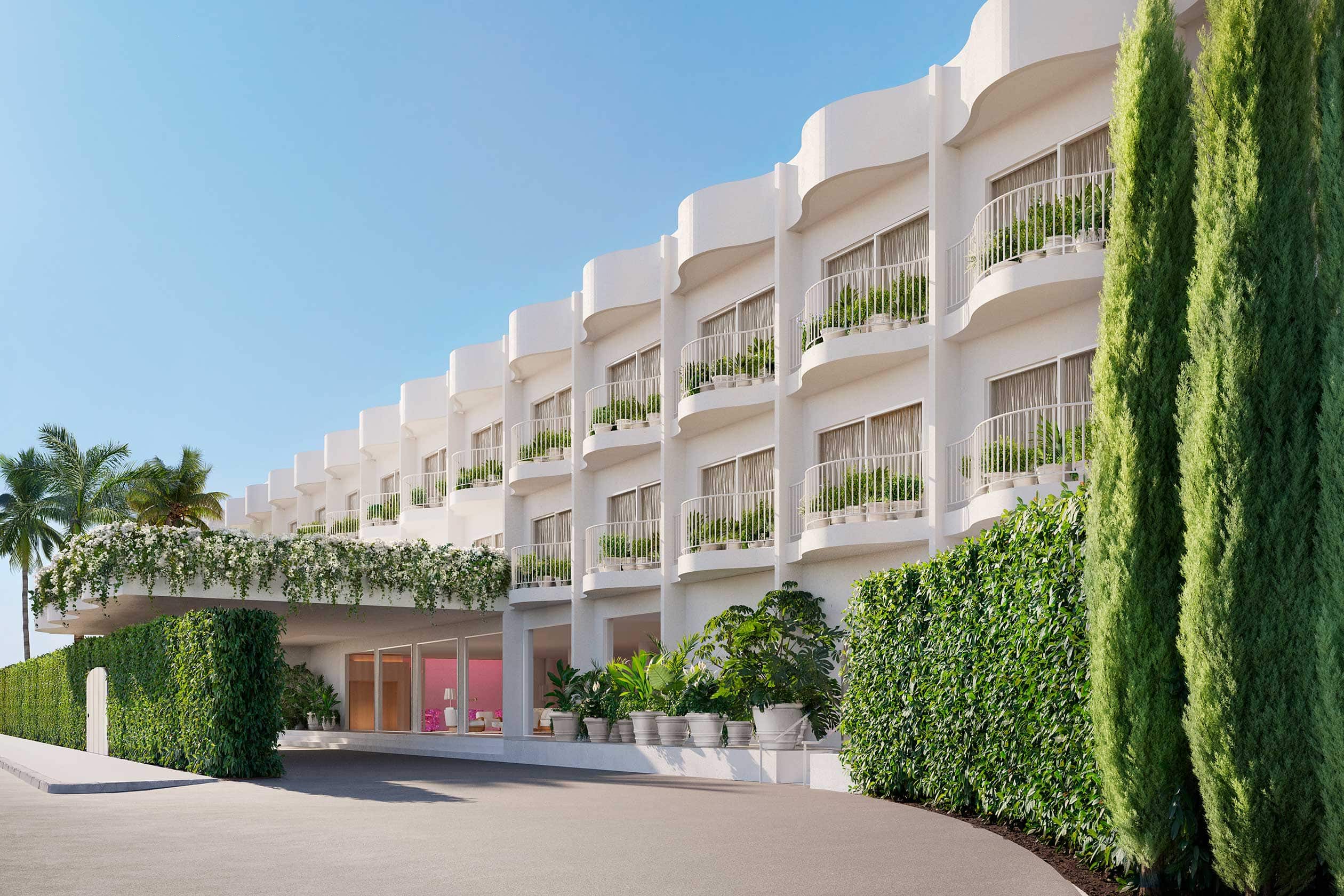The PUBLIC Hotel in West Hollywood, a modern white building with balconies and greenery, featuring a covered entrance and surrounded by lush plants and trees under a clear blue sky.